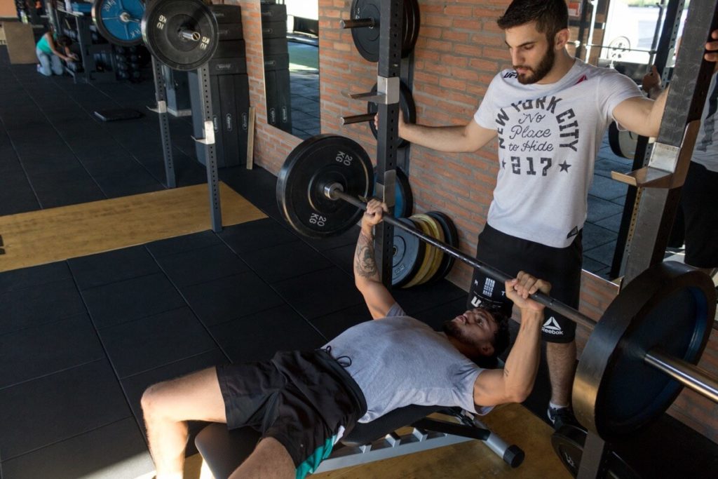 man spotter bench press gym